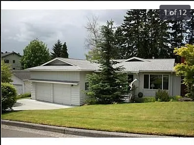 A house with a grey roof and a white garage door.
