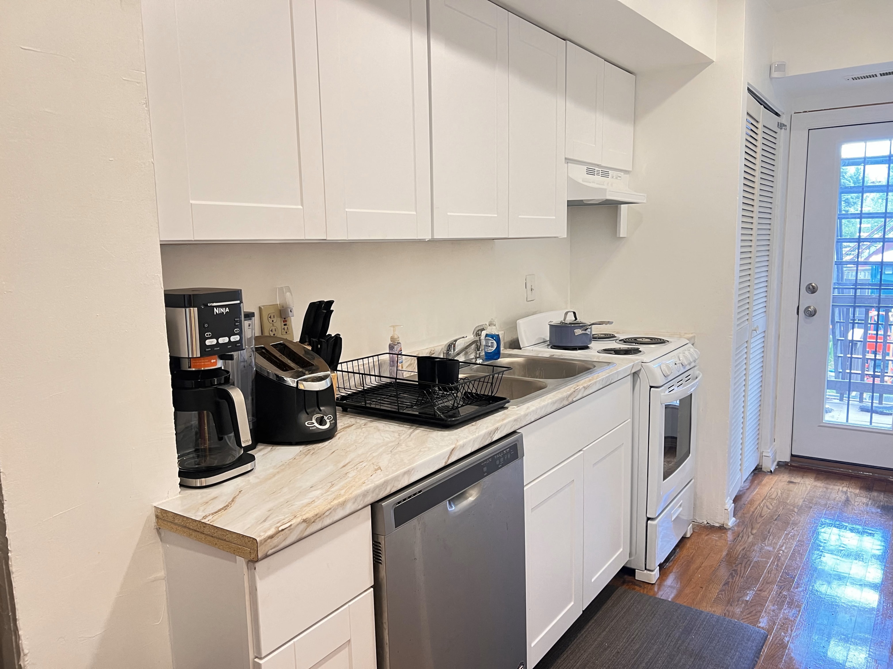 a kitchen with white cabinets and a sink and a dishwasher