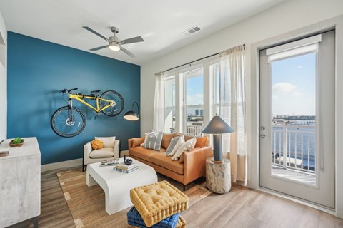 A living room with a yellow sofa and a bicycle on the wall.