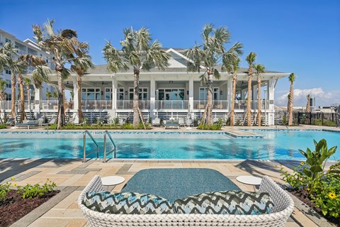 A pool area with a wicker chair and a pool table.
