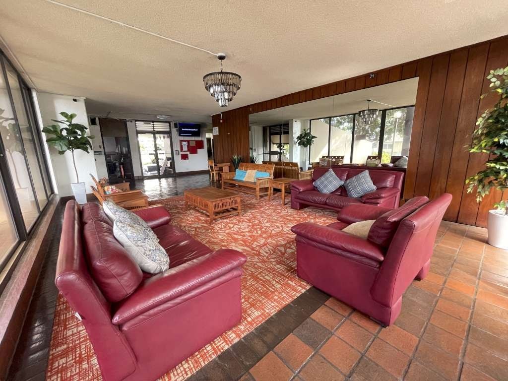 A living room with red couches and a chandelier.