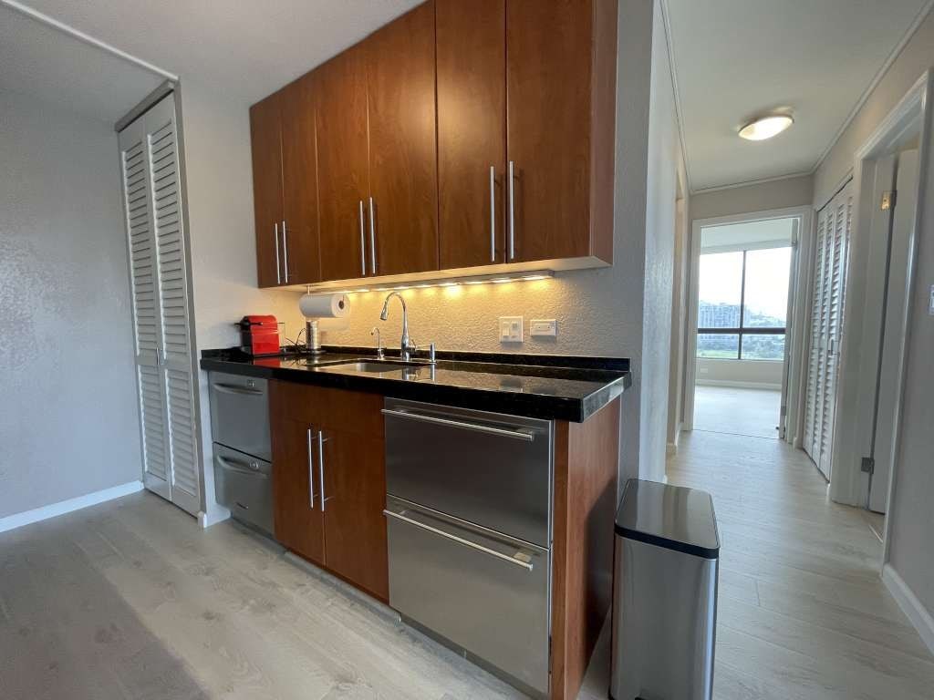 A kitchen with wooden cabinets and a black countertop.