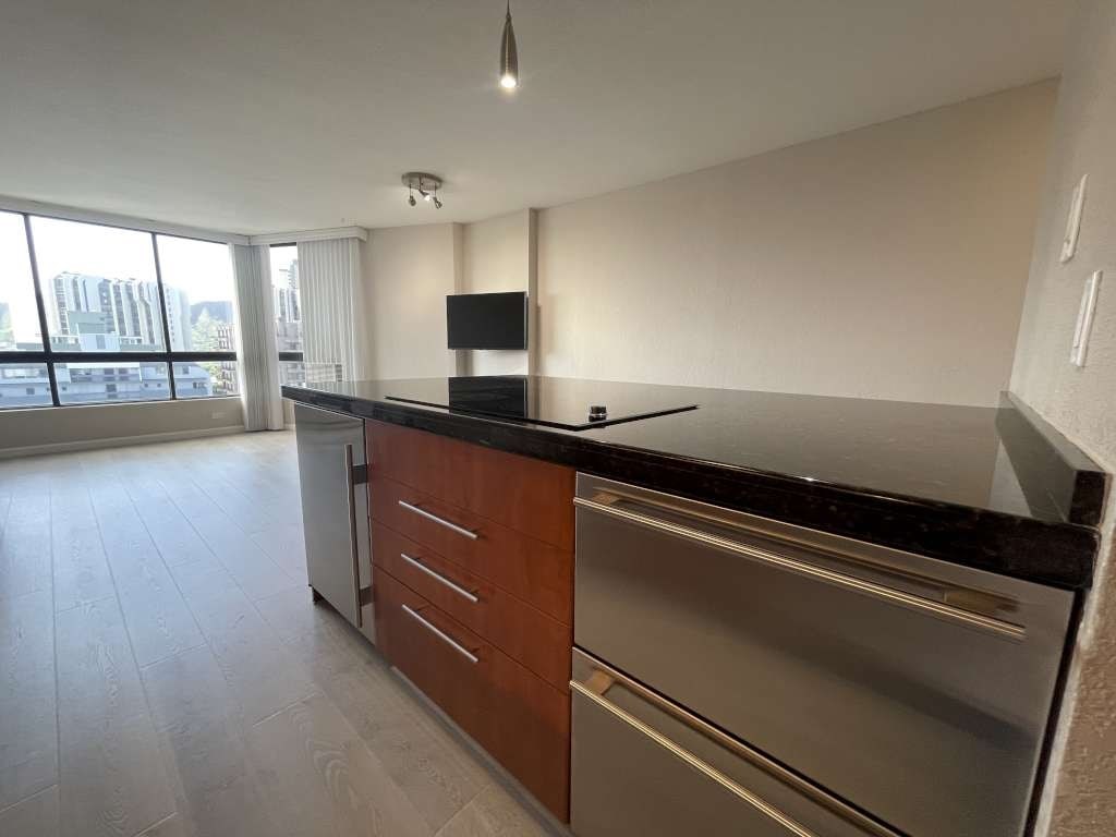 A modern kitchen with a stainless steel refrigerator and wooden cabinets.