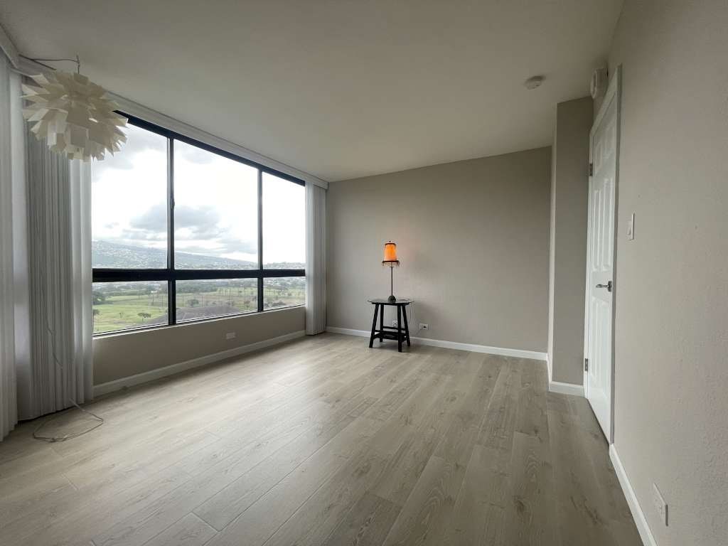 A room with a large window overlooking a landscape.