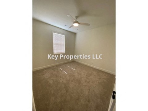 A room with a fan and a sign that says Key Properties LLC.