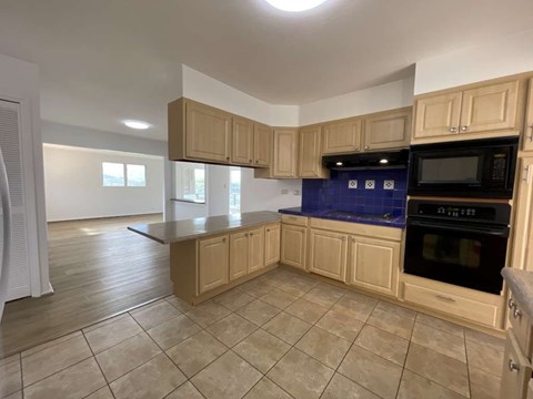 A kitchen with wooden cabinets and a blue backsplash.