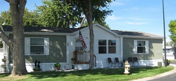 A house with a grey and white exterior and an American flag hanging on the front.