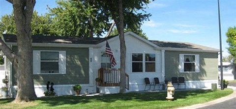A house with a grey and white exterior and an American flag hanging on the front.