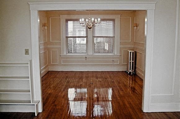 an empty living room with a wooden floor and a window