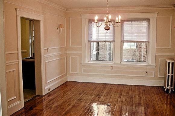 a living room with a wooden floor and a window
