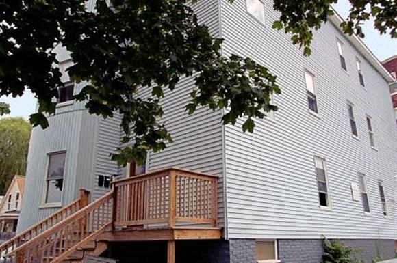 a white house with a porch and a tree