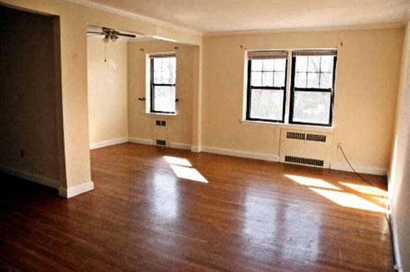an empty living room with wood floors and windows
