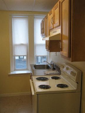 a kitchen with a stove and a sink and a window