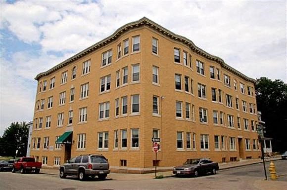 a large brick building with cars parked in front of it