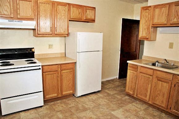 a kitchen with a stove a refrigerator and a sink