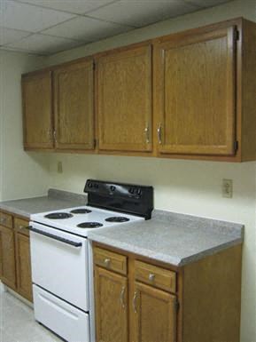 a kitchen with a stove top oven and cabinets