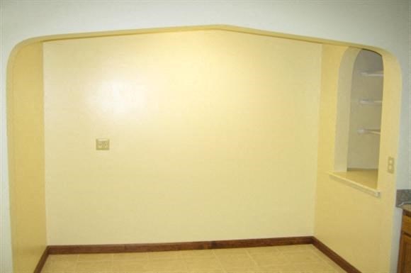 an empty room with an arch in the wall