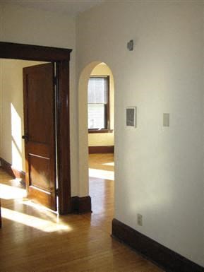 an empty room with a wooden floor and an open door