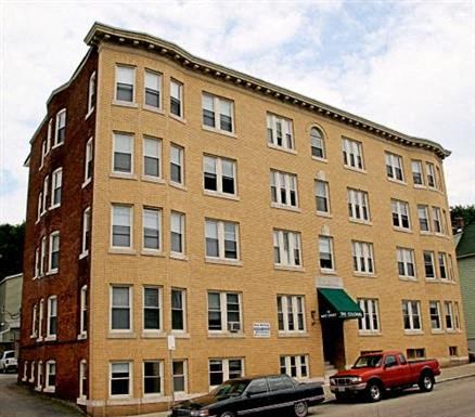 a large brick building with cars parked in front of it