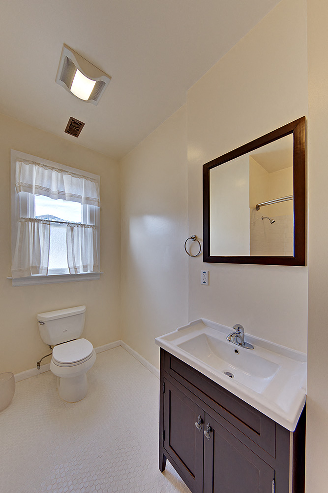 a bathroom with a toilet and a sink and a mirror