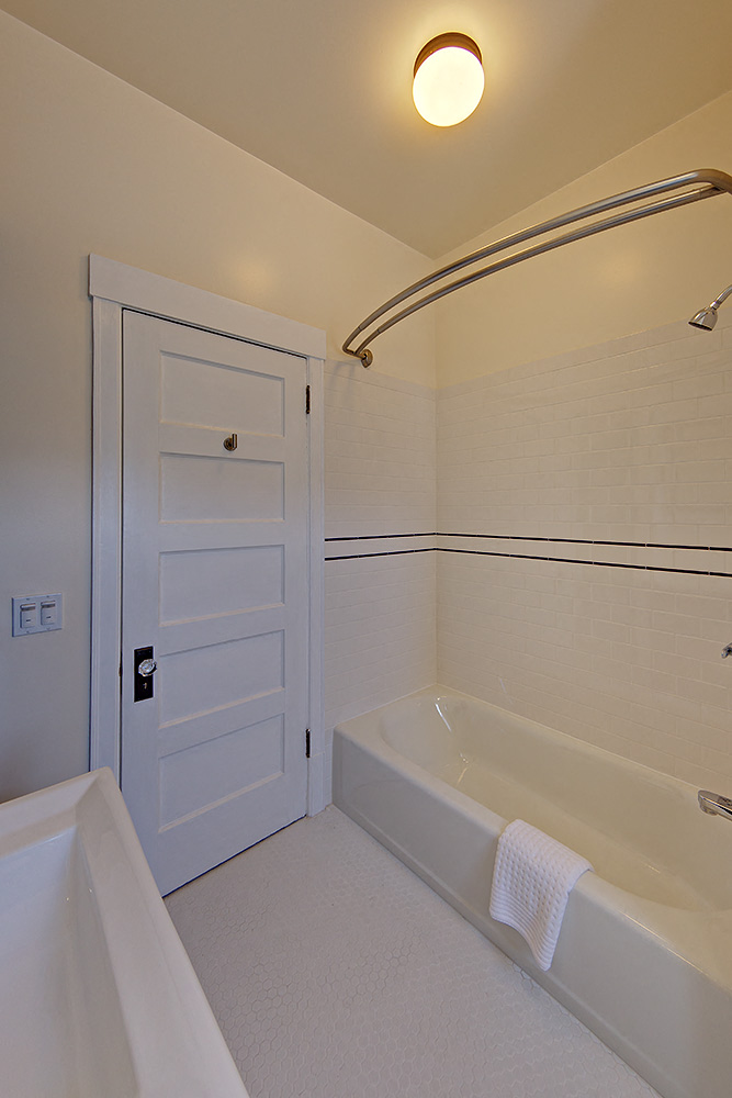 a bathroom with a white tub and a white door