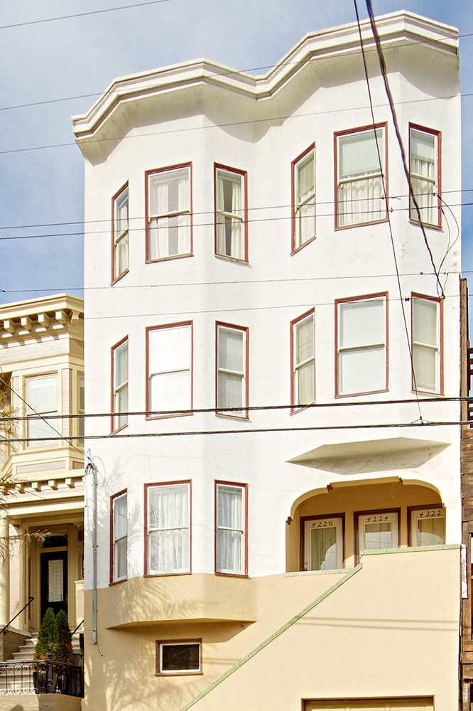 a white house with red windows on a street