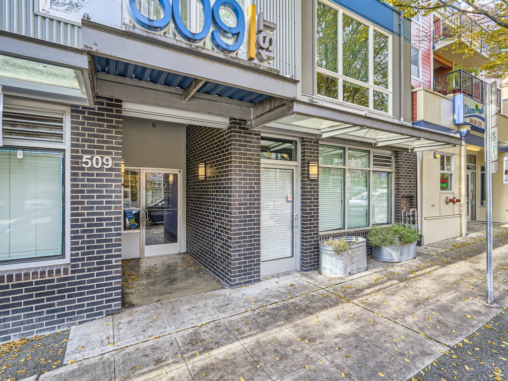 Street level entrance to 509 1st with brick detailing and large storefront windows in Seattle.