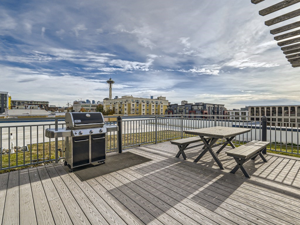 the deck has a grill and a picnic table on it