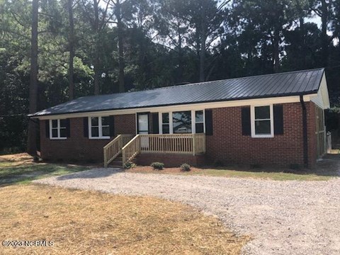 a small brick house with a porch and a