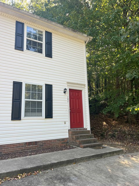 a red door on the side of a white house