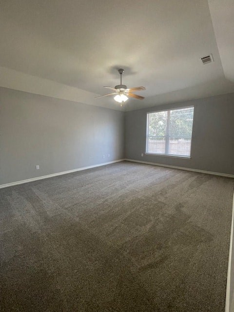 an empty living room with a ceiling fan and a window