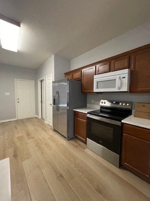 a kitchen with stainless steel appliances and wooden cabinets