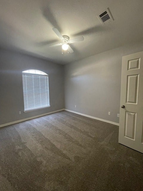 an empty room with a ceiling fan and a window