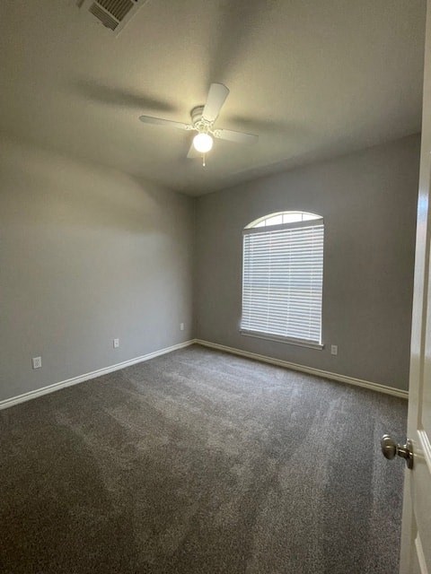 an empty room with a ceiling fan and a window