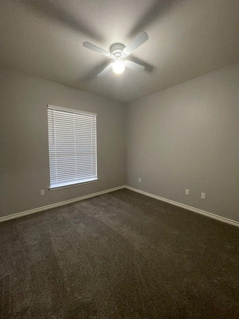 an empty room with a ceiling fan and a window