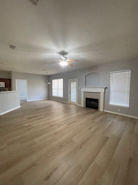 an empty living room with a fireplace and a ceiling fan