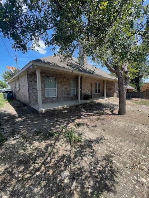 a small brick house with a tree in front of it