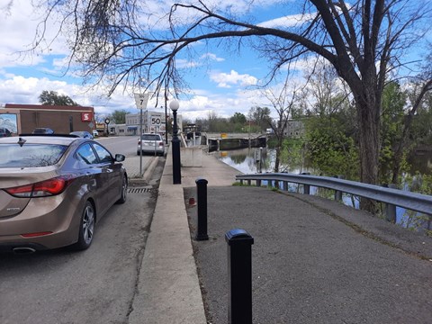 A parked car on the side of a road next to a sidewalk.