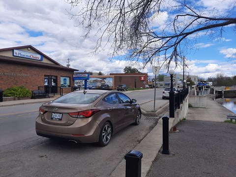 A brown car is parked on the side of the road.