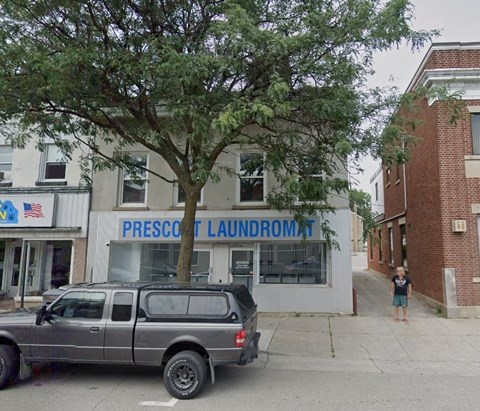 a truck parked in front of a building with a tree