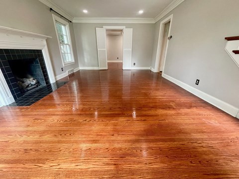 a living room with a wooden floor and a fireplace