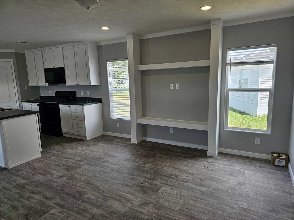 A kitchen with a black countertop and white cabinets.