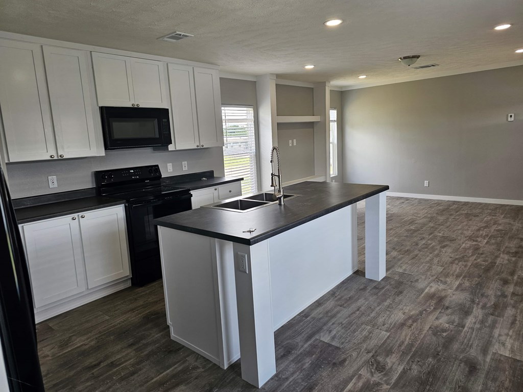 A kitchen with black countertops and white cabinets.