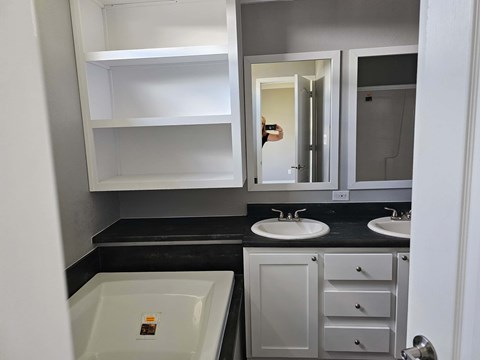 A bathroom with a white sink and a white cabinet.