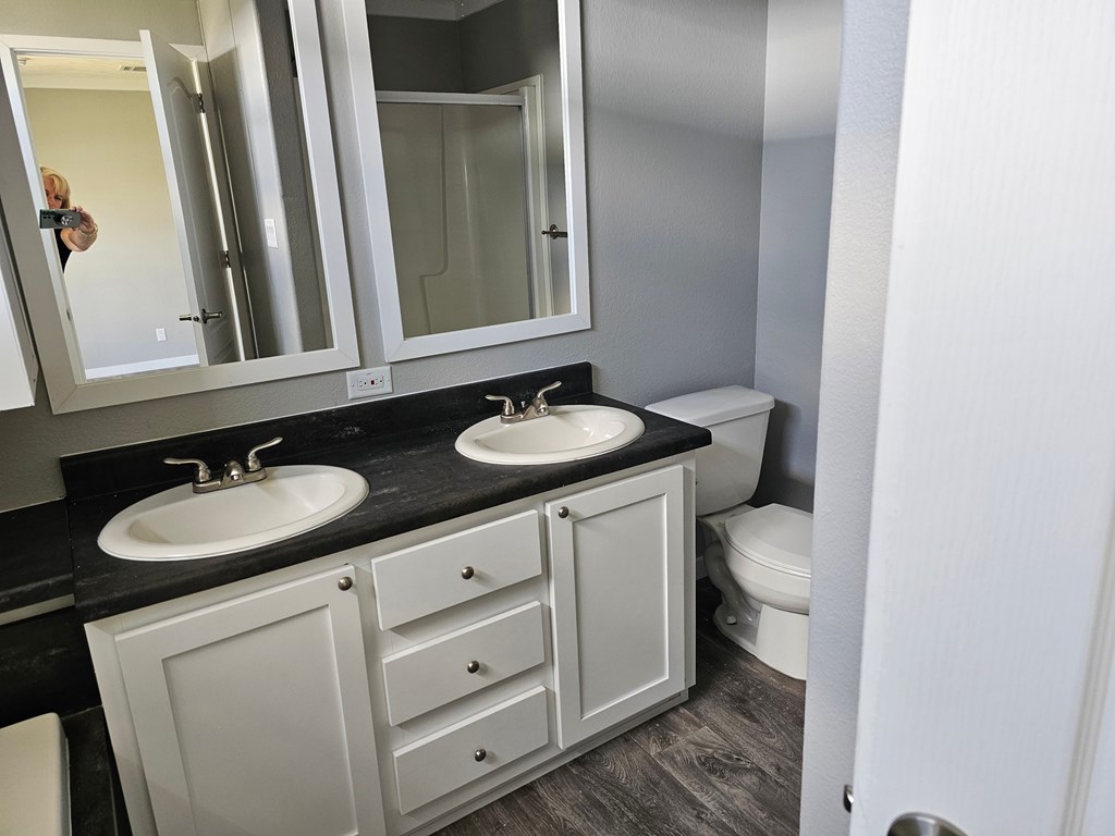 A bathroom with a sink, mirror, and toilet.