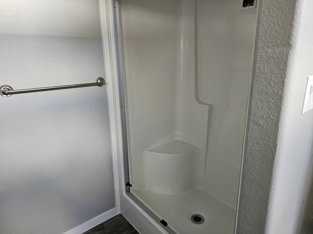 A white door with a handle and a small drain in the bottom.