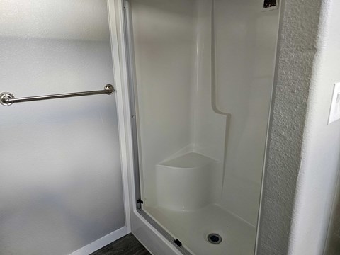 A white door with a handle and a small drain in the bottom.