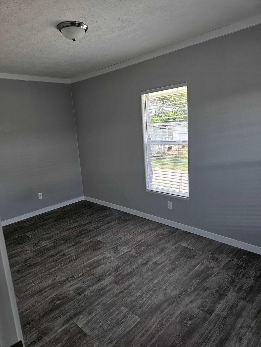 A room with a window and wooden flooring.