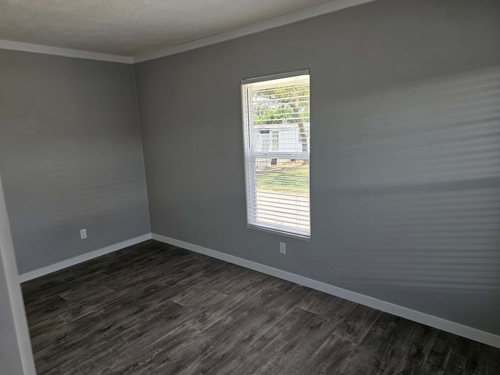 A room with grey walls and a window with blinds.