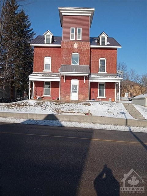 a red brick house on the side of a street